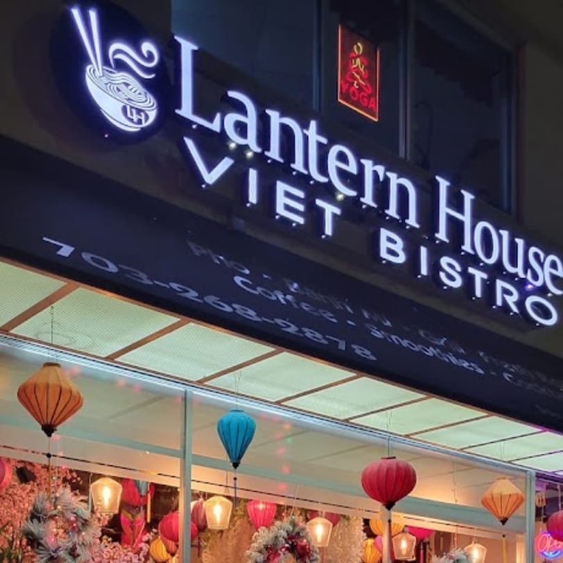 Exterior of Lantern House Viet Bistro with a glowing sign and colorful lanterns in the window.
