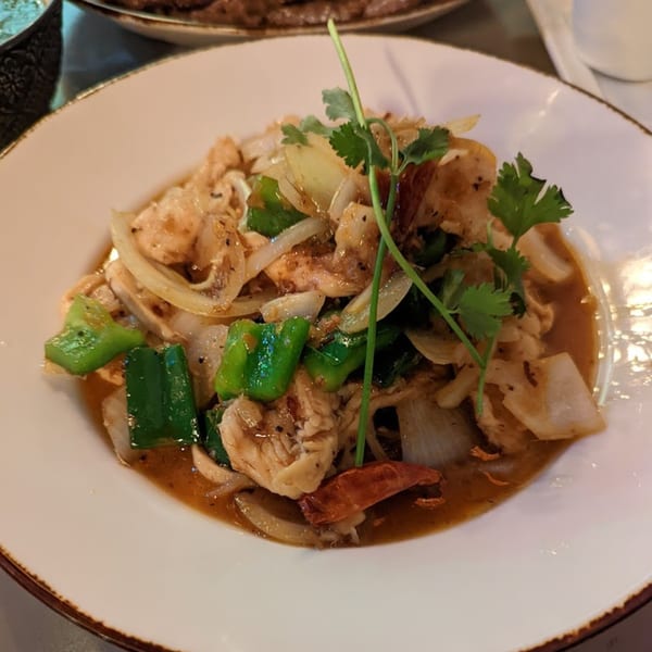 Vietnamese stir-fried chicken with onions, green peppers, and cilantro in a savory sauce.